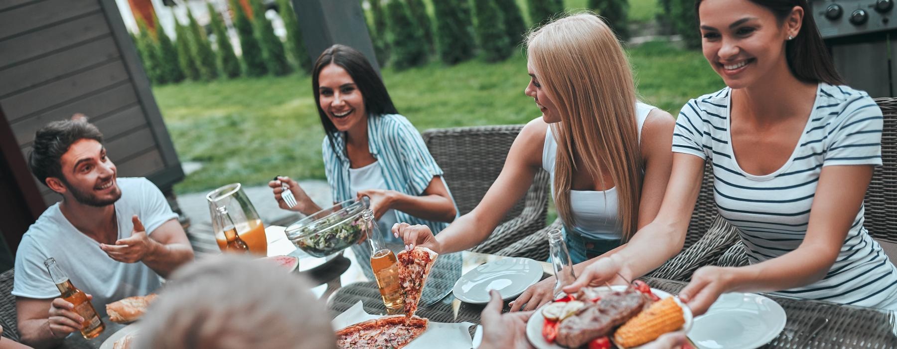 a group of people sitting around a table with food on it